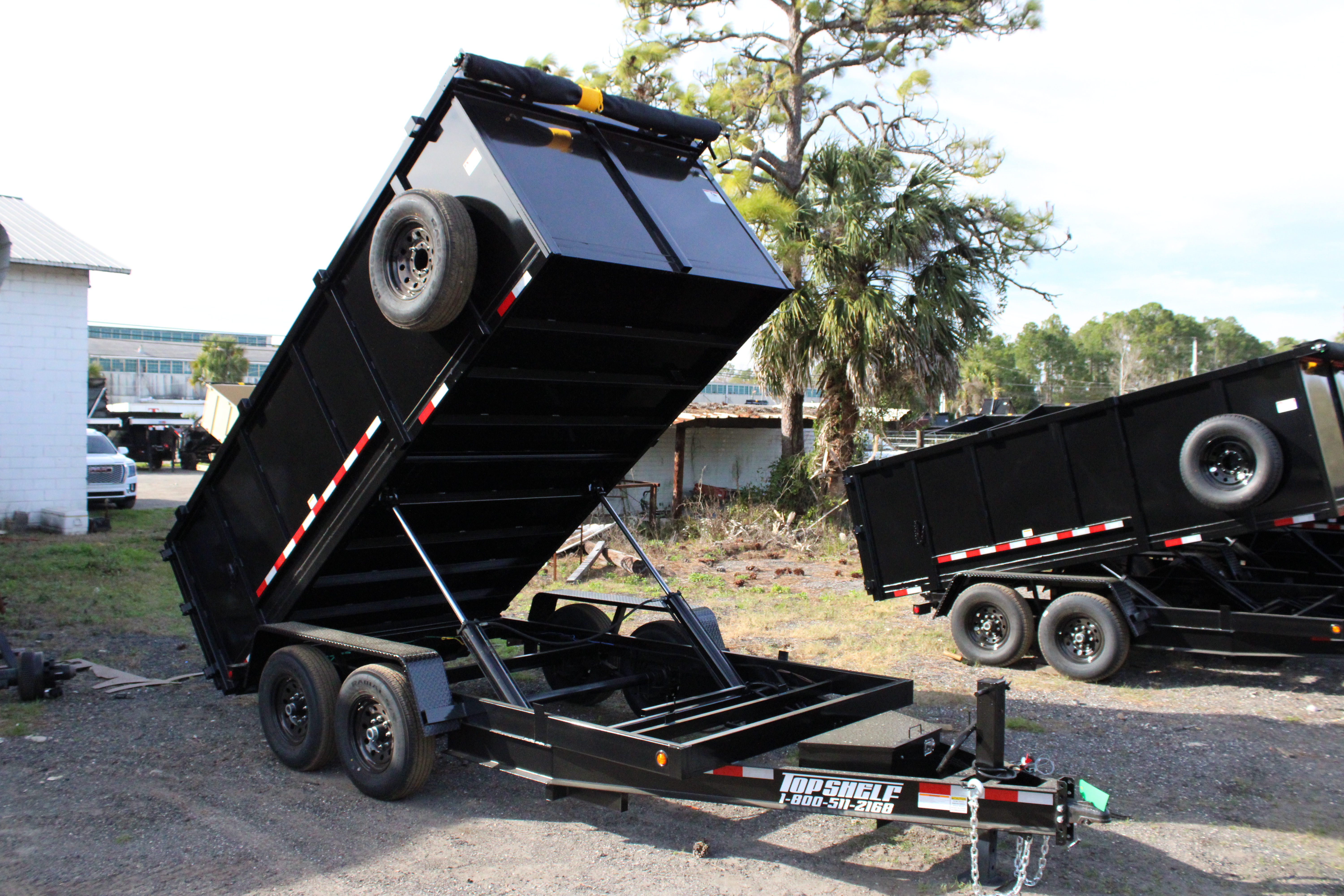 A fully loaded hydraulic dump trailer in action, efficiently unloading materials.